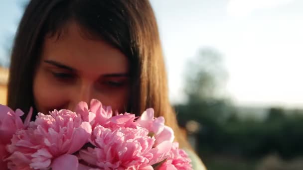Slow motion portret van een jonge mooie vrouw met een boeket van pioenrozen. — Stockvideo