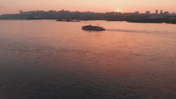 Vista aérea del barco que navega por el río en la ciudad al atardecer . — Vídeos de Stock