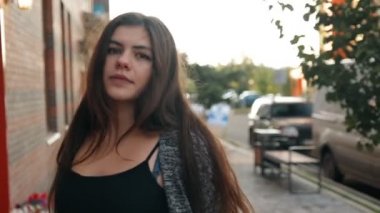 Şehir, rüzgarda çırpınan saç dolaşan seksi genç bir kadın portresi. Ağır çekim vurdu.