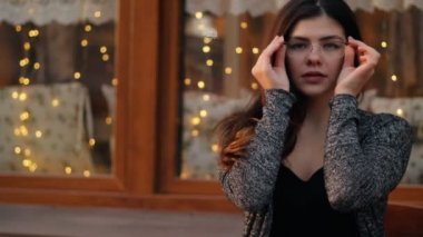 Ağır çekim bir açık şehir kafede oturan gözlüklü seksi iş kadını portresi.