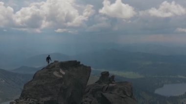 Dağın tepesine tırmanma bir adamın silueti hava atış.