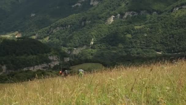 Turister med ryggsekker klatrer opp i fjellet. Turgåing i fjellet . – stockvideo