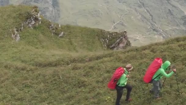 Luftaufnahme einer Gruppe von Touristen mit Rucksäcken, die den Berg besteigen. — Stockvideo