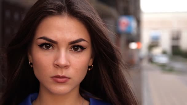 Porträtt snygg ung brunett kvinna tittar på kameran attraktiv kaukasisk kvinna klädd i blå pälsen i urbana staden. — Stockvideo