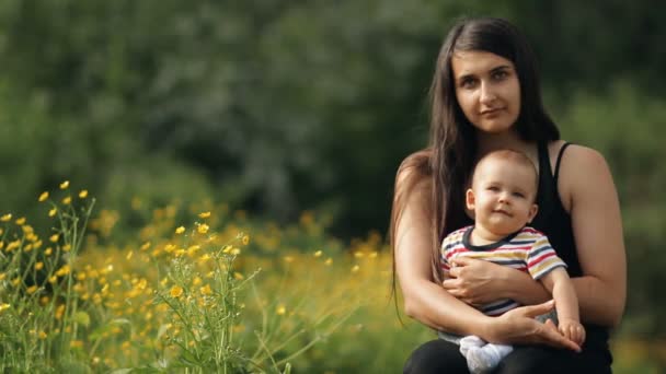 Retrato en cámara lenta de una mujer joven con un niño pequeño . — Vídeos de Stock