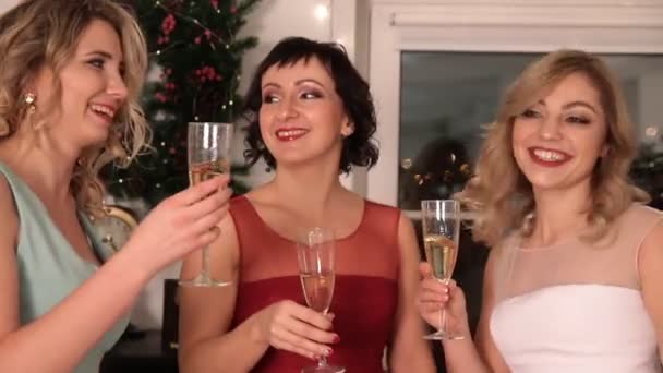 Tre unga attraktiva kvinnor nära julgranen. — Stockvideo