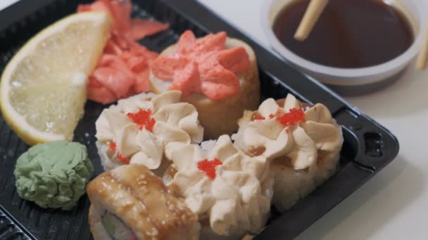 Hand neemt de sushi roll met zijn stokjes. — Stockvideo