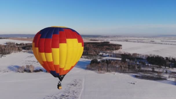 Colpo aereo della gente volare su un grande pallone luminoso sopra la foresta invernale . — Video Stock