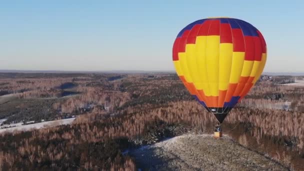 Tiro aéreo das pessoas voam em um grande balão brilhante sobre a floresta de inverno . — Vídeo de Stock