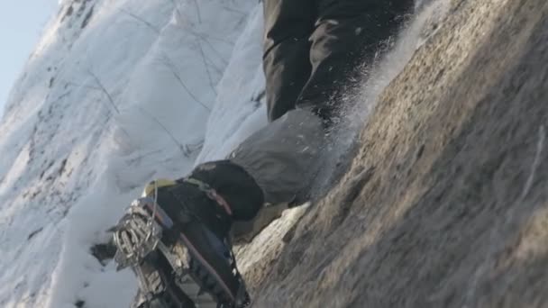 Close-up de botas alpinista escalando a montanha congelada . — Vídeo de Stock