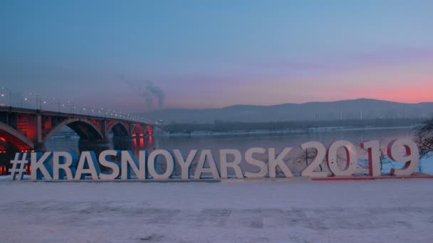 Krasnoyarsk, Rusya Federasyonu - 20 Ocak, 2019: Krasnoyarsk Bridge'de arka plan üzerinde Kış Üniversite Oyunları 2019 sembolü. — Stok video