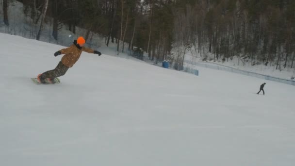 Een jonge man snowboarden. — Stockvideo