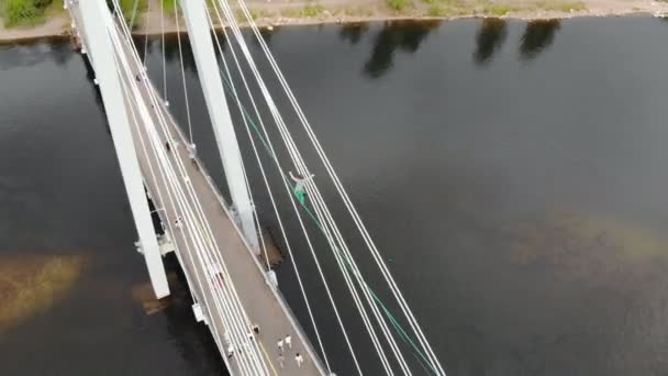 Krasnojarsk, Rusland-08 jun 2019: een man loopt op een touw gespannen tussen de steunen van de brug op grote hoogte. — Stockvideo