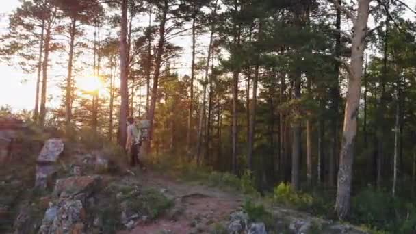 Flygbild av en ung man och hans lille son som färdas genom fjällen. Barn sitter i en ryggsäck på sin far bakom ryggen och beundra landskapet. — Stockvideo