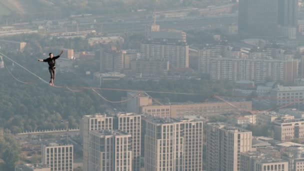 Moscú, Rusia - 8 Sep 2019: Un hombre equilibra en cuerda apretada, una vista de la ciudad desde la altura en la niebla . — Vídeo de stock