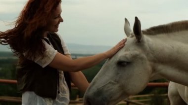 Bir kadın açık havada hipoterapi yapıyor..