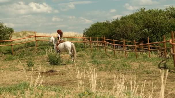 Молодая рыжая женщина едет верхом на лошади . — стоковое видео