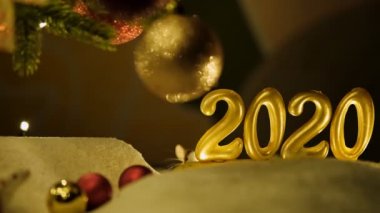 Yeni yılın sembolü olan 2020 işaretinin arkasından gri bir sıçan çıkıyor..