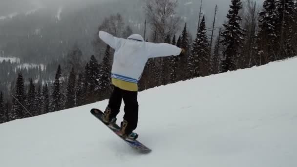 Lassú mozgás egy férfi snowboardos ugrás a lejtőn. — Stock videók