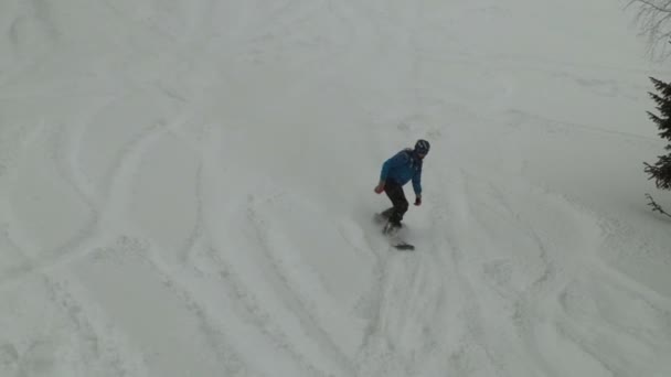 Vista superior de um homem montando um snowboard em um pó . — Vídeo de Stock