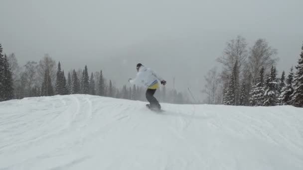 Sheregesh, Rusko - 07 Březen, 2019: Zpomalený pohyb muže na snowboardu z hory a dělá triky. — Stock video