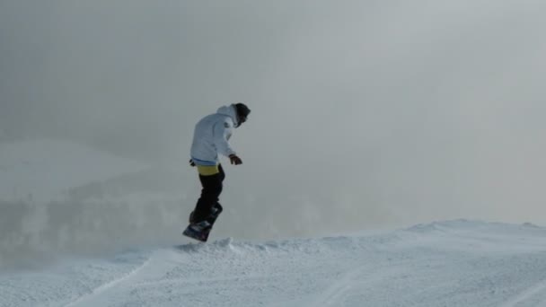 Шерегеш, Россия - 07 марта 2019 года: Медленное движение человека, спускающегося на сноуборде с горы и делающего трюки . — стоковое видео