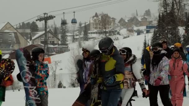 Sheregesh, Rússia - 07 de março de 2019: Movimento lento de um grupo de snowboarders em uma estância de esqui . — Vídeo de Stock