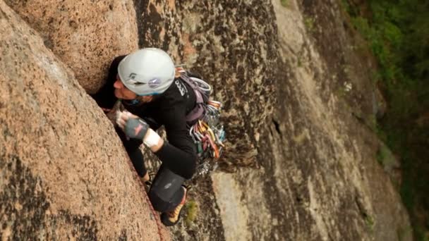 Krasnoyarsk, Rusia-15 de julio de 2019: Concursos de montañismo. Campeonato de Rusia en la clase de rock. Una mujer montañista sube a una pared dura de granito . — Vídeo de stock