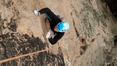 Krasnoyarsk, Rusya-15 Temmuz 2019: Dağcılık Yarışmaları. Rock sınıfında Rus şampiyonluğu. Erkek bir tırmanışçının yavaş hareketi bozulur ve sigortaya tutunur..