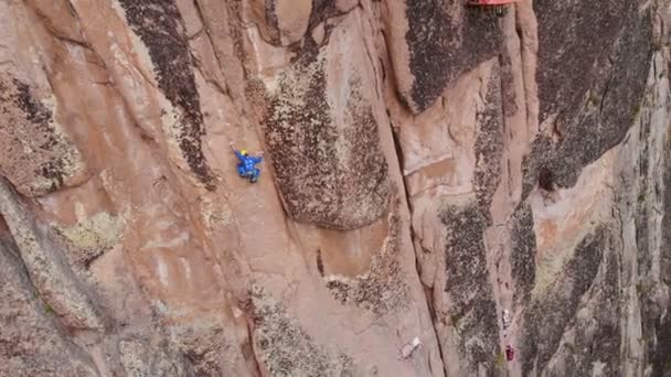 Krasnoyarsk, Rusia-15 de julio de 2019: Concursos de montañismo. Campeonato de Rusia en la clase de rock. Vista aérea de un hombre escalando un alto muro de piedra . — Vídeo de stock