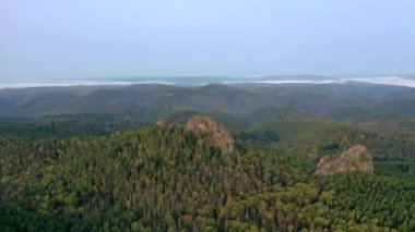 Şafak vakti ormandaki kaya tepelerinin hava hızında düşüşü. Stolby Ulusal Parkı, Krasnoyarsk, Rusya.