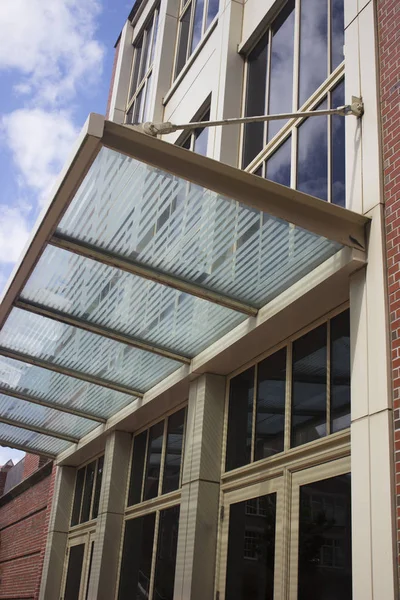 Cam pencere panelleri ve gökyüzü yansıması ile bina kapı tuğla