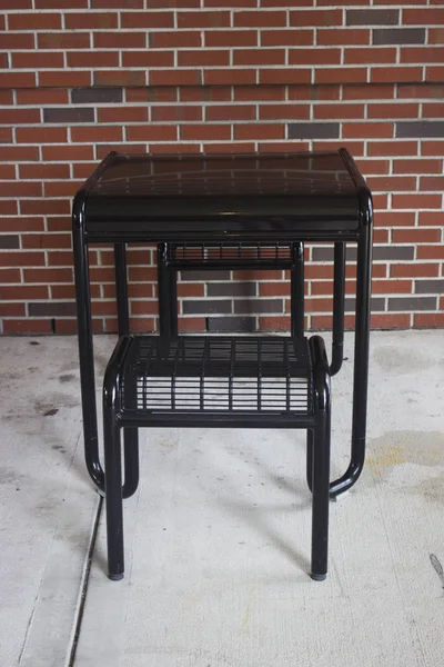 Siyah boş masa ve sandalye tuğla bina önünde ayarla