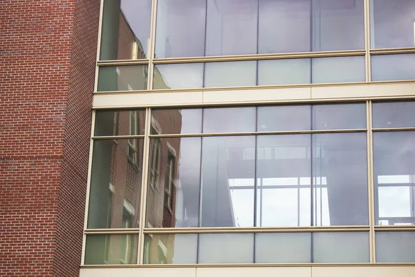 Brick university campus facade with building reflection on glass window