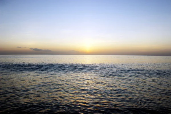 Güzel mavi okyanus üzerinde turuncu günbatımı
