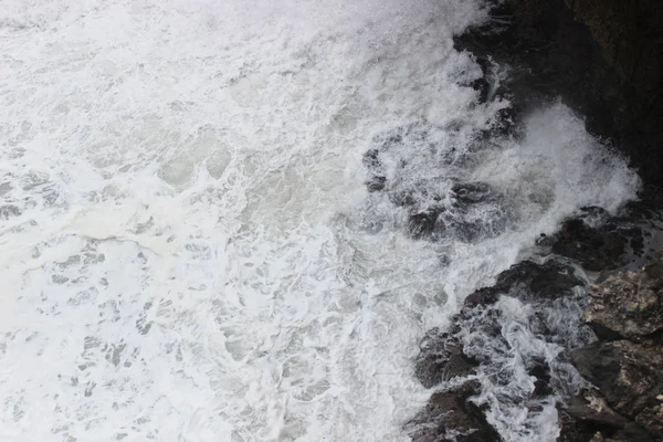 Beyaz deniz köpük dalgalar çökmesini kayaya