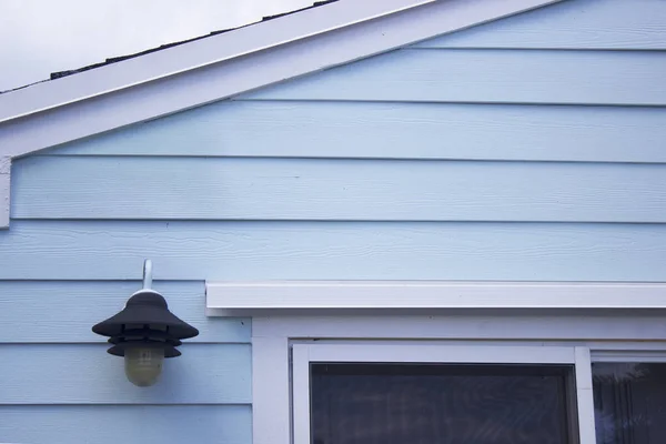 Mavi shiplap evin dış ışık ve beyaz sürgülü cam kapı ile