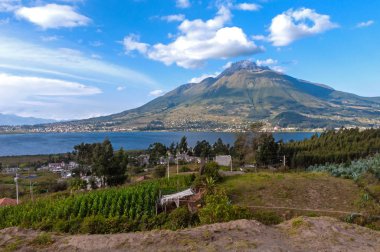 Beautiful view of the Imbabura volcano, the San Pablo lake and green fields, on a beautiful day. Ecuador, South America clipart