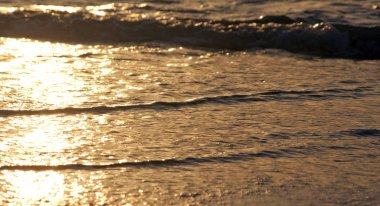 Clearwater Beach, Florida, Usa 'da günbatımında kumların üzerinde birkaç küçük ve yumuşak dalga.