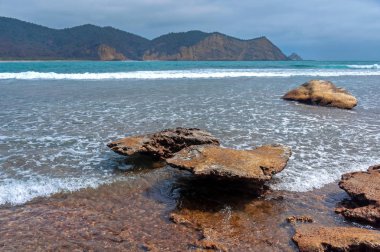 Arka planda okyanus ve gökyüzü olan her boyutta kayalar, bulutlu bir günde, Los Frailes Sahili Ulusal Parkı, Manabi, Ekvador