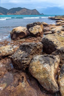 Arka planda okyanus ve gökyüzü olan her boyutta kayalar, bulutlu bir günde, Los Frailes Sahili Ulusal Parkı, Manabi, Ekvador
