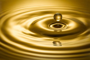 Golden Liquid droplet. The rebount of a drop in the golden water - stock image clipart
