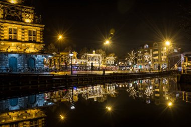 Alkmaar, Hollanda - Ocak 2018: Alkmaar'daki kanallarmanzarası. Hollanda'nın en eski şehirlerinden birinde eski ve yeni binalar bulunmaktadır