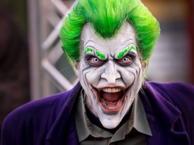 Boyalı Joker maskeli genç adamın yakın plan portresi.
