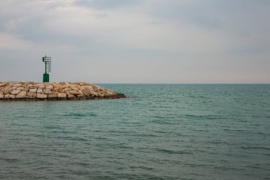 Sakin deniz ve küçük taş dalgakıran, Rodi Garganico marinasının girişi İtalya