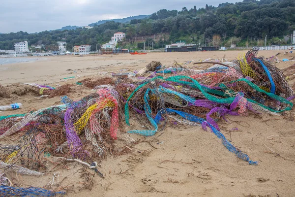 Colorful nets on beach. Trash in nature. Ecology crisis concept