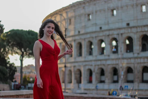 Krásná mladá dívka v červených šatech před Koloseum, Řím, Ital — Stock fotografie