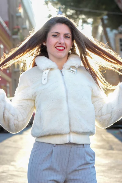 Молодая смеющаяся женщина в белой куртке — стоковое фото