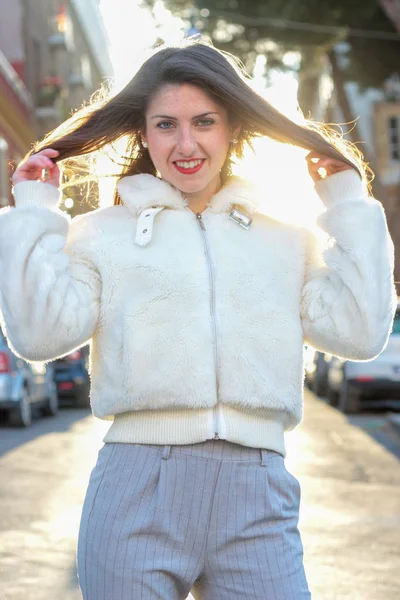 Joven mujer riendo con chaqueta blanca Imagen De Stock
