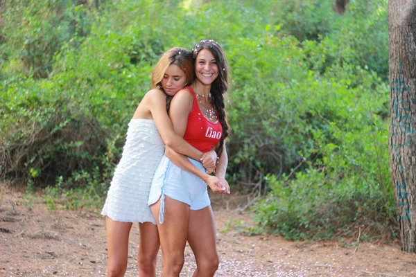 Duas jovens raparigas felizes abraçam-se. Amigos femininos abraçando . — Fotografia de Stock